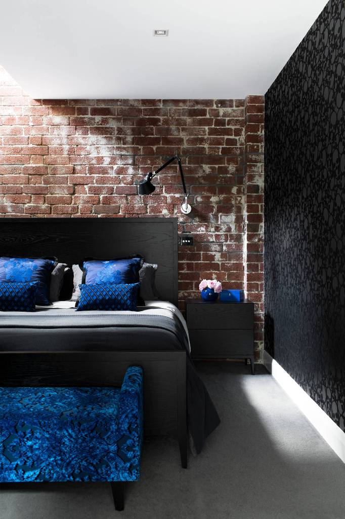 Contrast on brick walls, black bed with electric blue