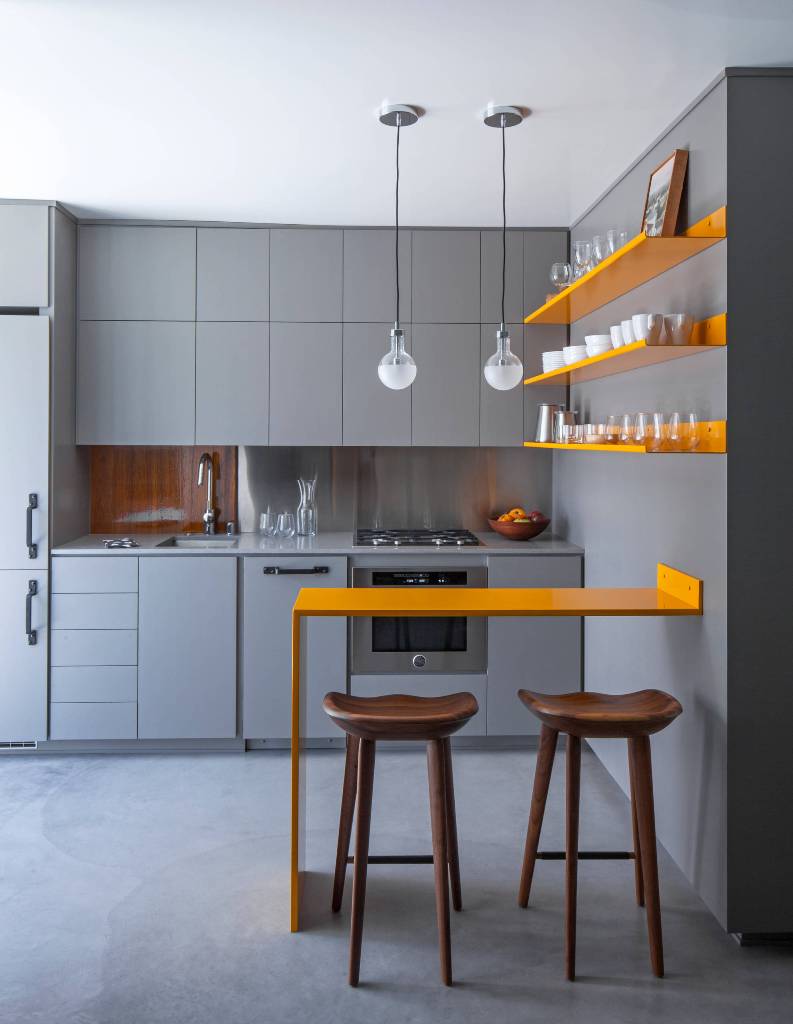 Small modern kitchen with concrete floor with a wall
