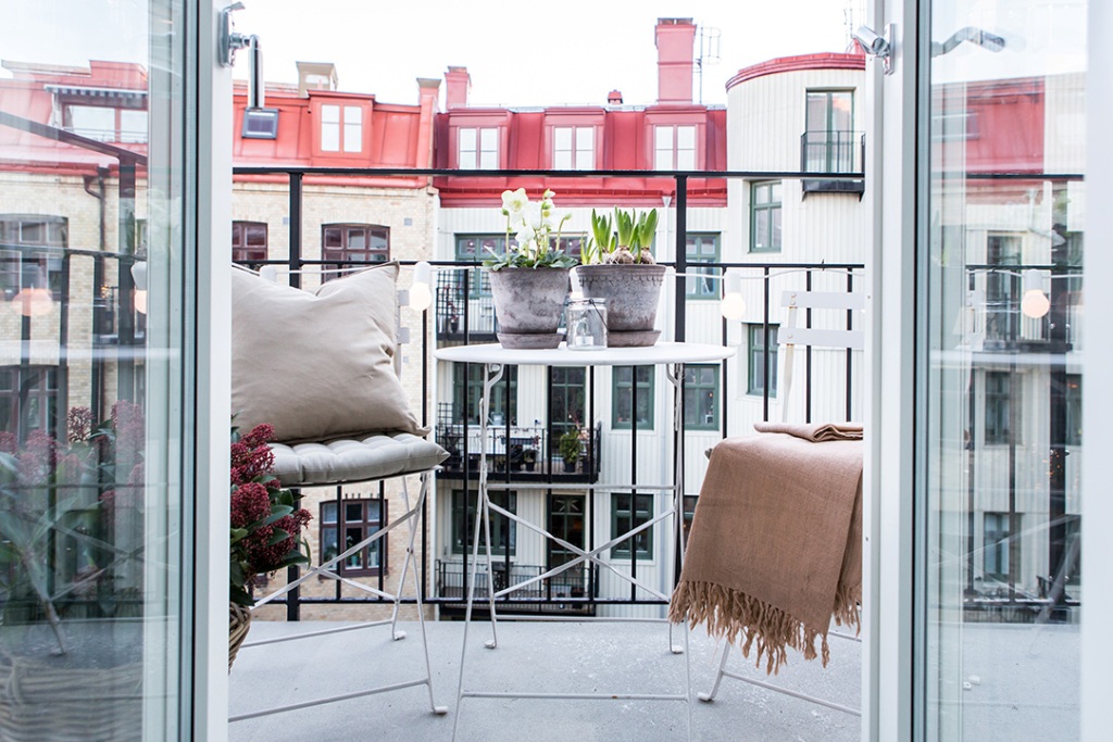 cute balcony with flower pot and two chairs