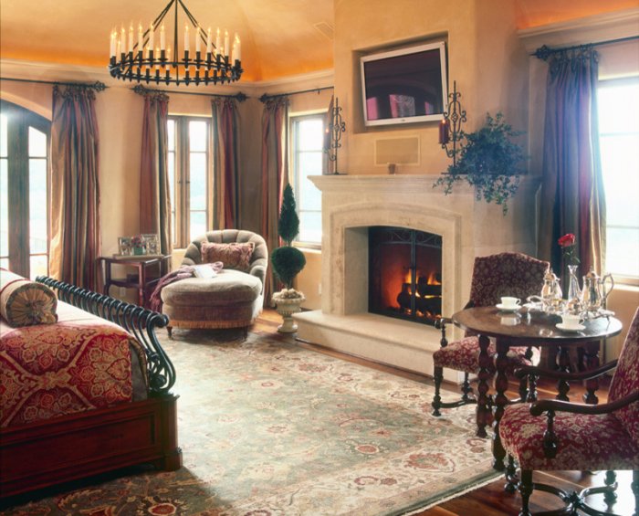 cozy-bedroom-with-a-fireplace-club-chairs-and-antique-table-and .