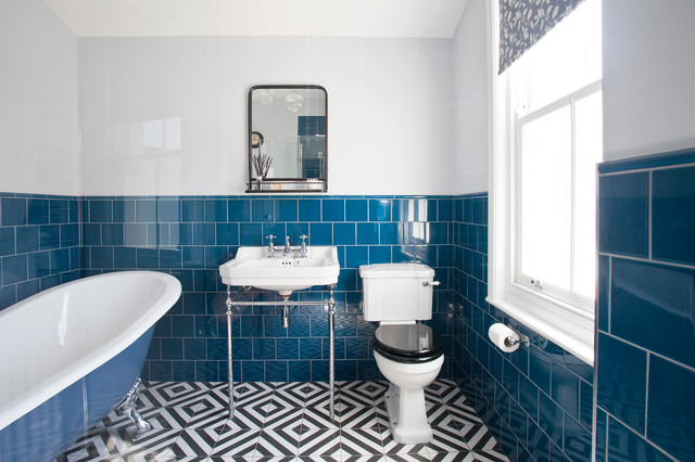Blue-tiled main bathroom with slipper bath and geometric flooring .