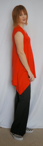 asymmetrical sleeveless tunic with black pants with wide legs