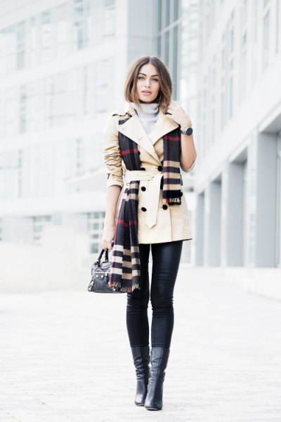 beige trench coat with belt and black and white checked scarf