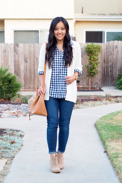 black and white checked shirt with white cardigan and blue skinny jeans