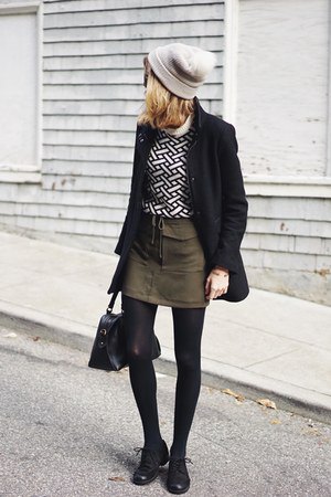 black and white patterned sweater with a green mini waist skirt
