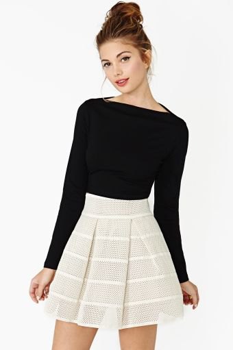 black long-sleeved top with boat neckline and light pink minirater skirt