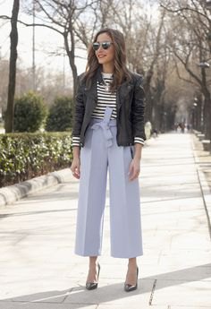 black bomber jacket with black and white striped sweater and blue pants with wide legs