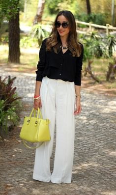 black shirt with button and white pants and lemon yellow leather handbag