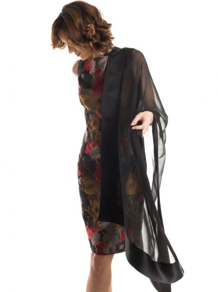 black chiffon cape with dark, figure-hugging midi dress with floral pattern