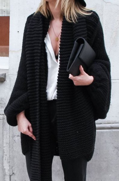 black, coarsely knitted cardigan with white blouse and leather handbag
