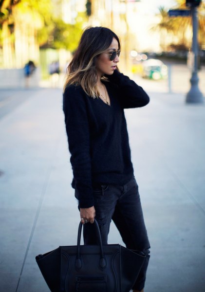 black, coarsely knitted sweater with V-neck and dark, narrow-cut jeans