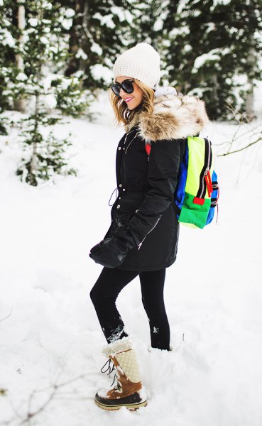 black coat with leggings and white and brown mid-calf snowshoes