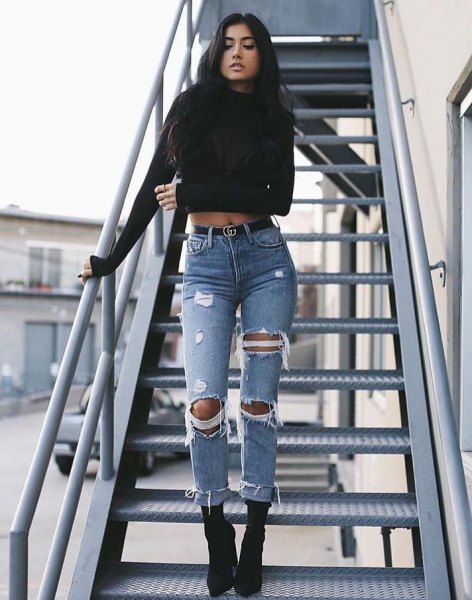 black, cropped sweater with a round neckline and ripped jeans