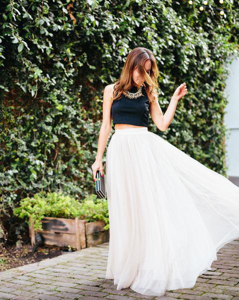 black, short, sleeveless top with white, high-waisted maxi pleated skirt