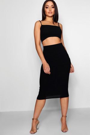 black, short-cut vest top with a square neckline and a high-waisted, figure-hugging midi skirt