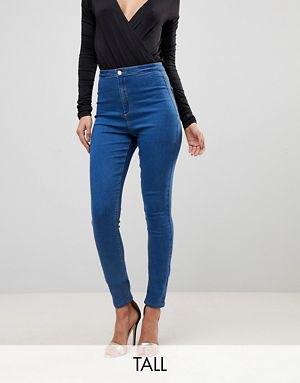 black, deep-fitting, long-sleeved top with V-neckline and blue, tall jeans