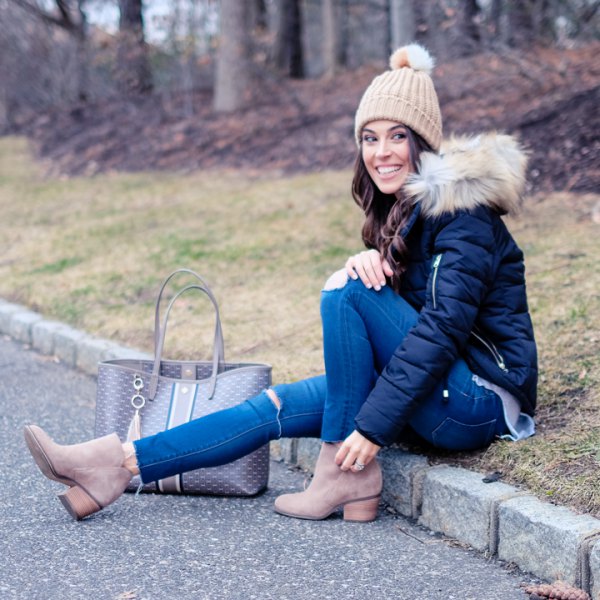 black down jacket with blue skinny jeans and crepe knitted hat