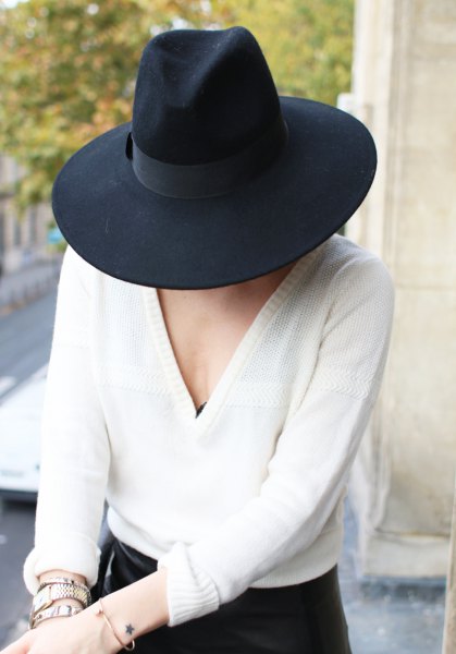 black felt hat with white pullover with V-neck and skinny jeans