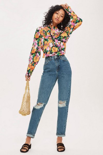 black blouse with floral pattern and blue ripped jeans