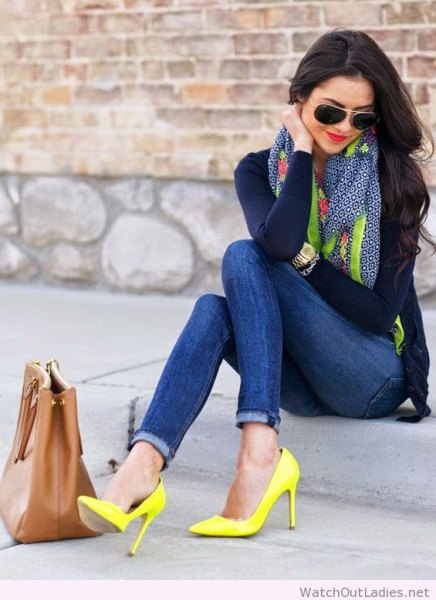 Black, figure-hugging long-sleeved T-shirt with skinny jeans and yellow high heels