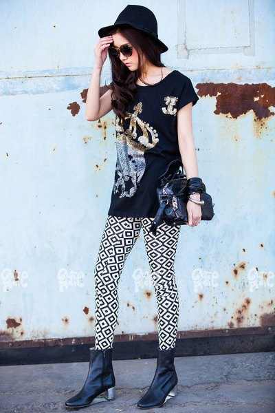 black graphic t-shirt with high-heeled leather boots and a felt hat