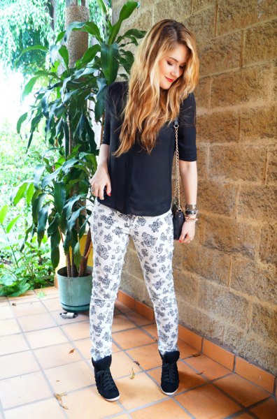 black sweater with half sleeves and white and pink printed pants with a relaxed fit