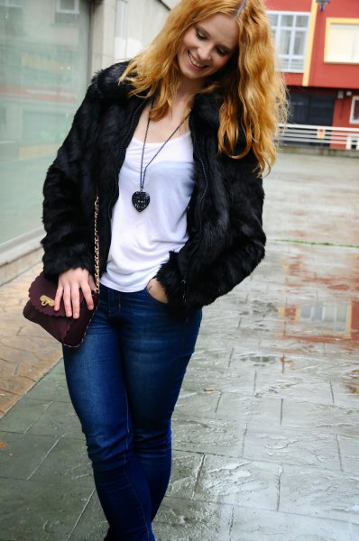black jacket with a white t-shirt with a scoop neckline and blue jeans with a slim fit