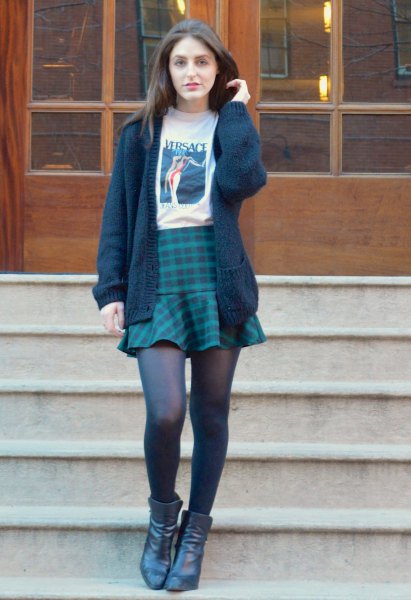black knitted sweater with white printed t-shirt and dark blue plaid skirt