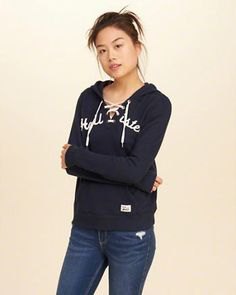 Graphic hoodie with black lace-up neckline and dark blue skinny jeans