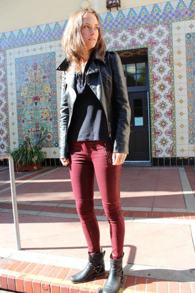black leather jacket with green coated skinny jeans