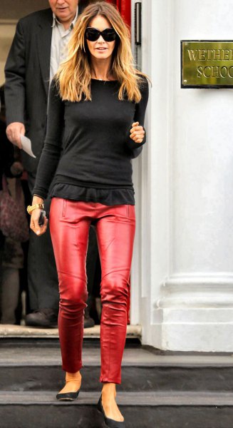 black, long-sleeved, figure-hugging T-shirt with ruffles and red trousers