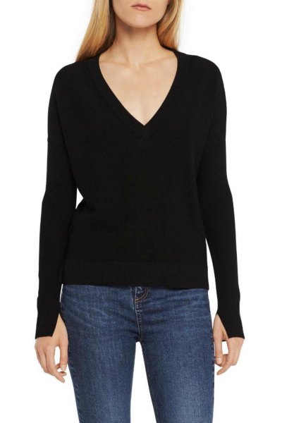 black knitted sweater with deep V-neck and dark blue skinny jeans