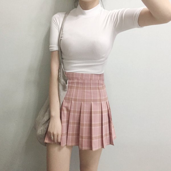 black, figure-hugging T-shirt with stand-up collar and pink pleated mini skirt with high waist