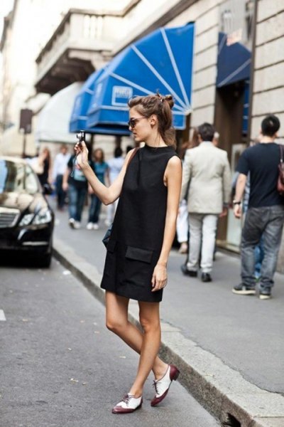 black minidress with stand-up collar and white and gray Oxford dress shoes