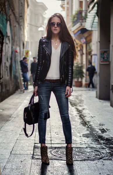 black moto jacket with white chiffon blouse with V-neck and boots with leopard print