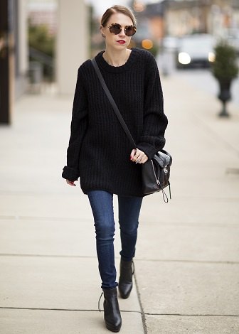 black oversized sweater with blue skinny jeans and leather ankle boots