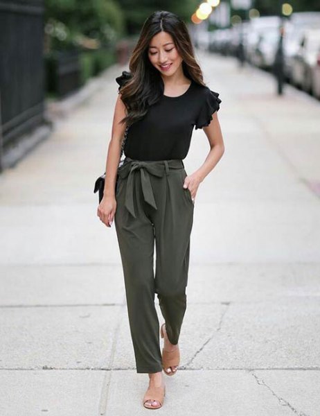 black t-shirt with ruffle sleeves and army green slim fit trousers on the front