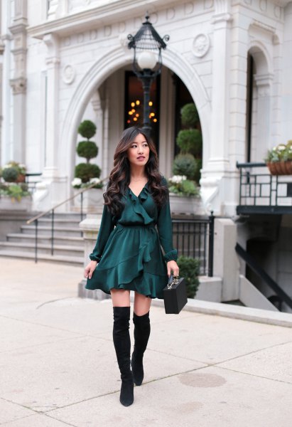 black blouse with V-neckline with ruffles, matching skater skirt and flat over-the-knee boots