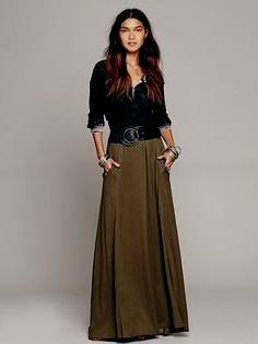 black blouse with scoop neckline and green maxi skirt with belt