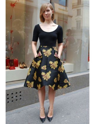 black, figure-hugging top with a scoop neckline and half sleeves and a knee-length skater skirt with a floral pattern