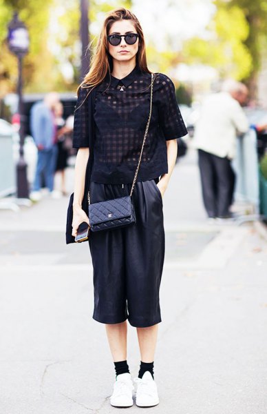 black, semi-transparent short-sleeved blouse with cropped trousers with wide legs made of leather