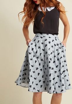 black sleeveless top with white printed midi skirt made of flared chiffon with pockets