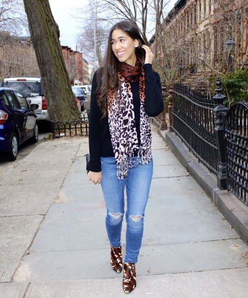 black sweater with scarf with leopard print and light blue jeans