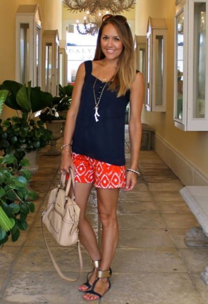 Relaxed tank top with a black sweetheart neckline and orange shorts with a tribal print
