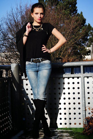 black t-shirt with studded belt and knee-high boots