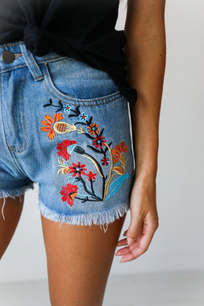 black tank top with blue embroidered denim shorts with floral pattern