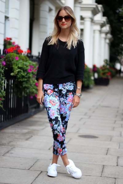 black three-quarter sleeve sweater with blue-cut trousers with a floral pattern and white sneakers