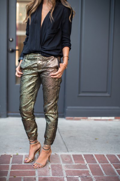 black blouse with V-neckline and slim-fitting trousers made of sequined gold