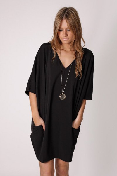 black tunic dress with V-neckline and long necklace