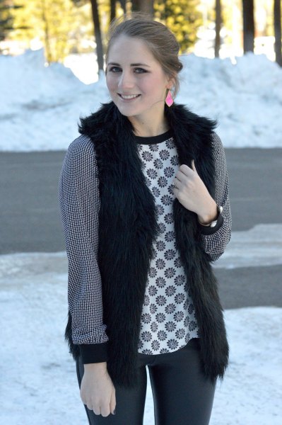 black vest with tribal-printed long-sleeved top and dark gray jeans